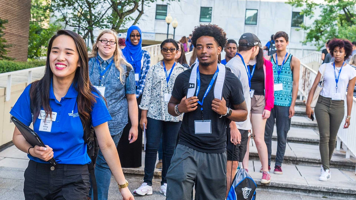 Student leader walks with new students on campus during orientation